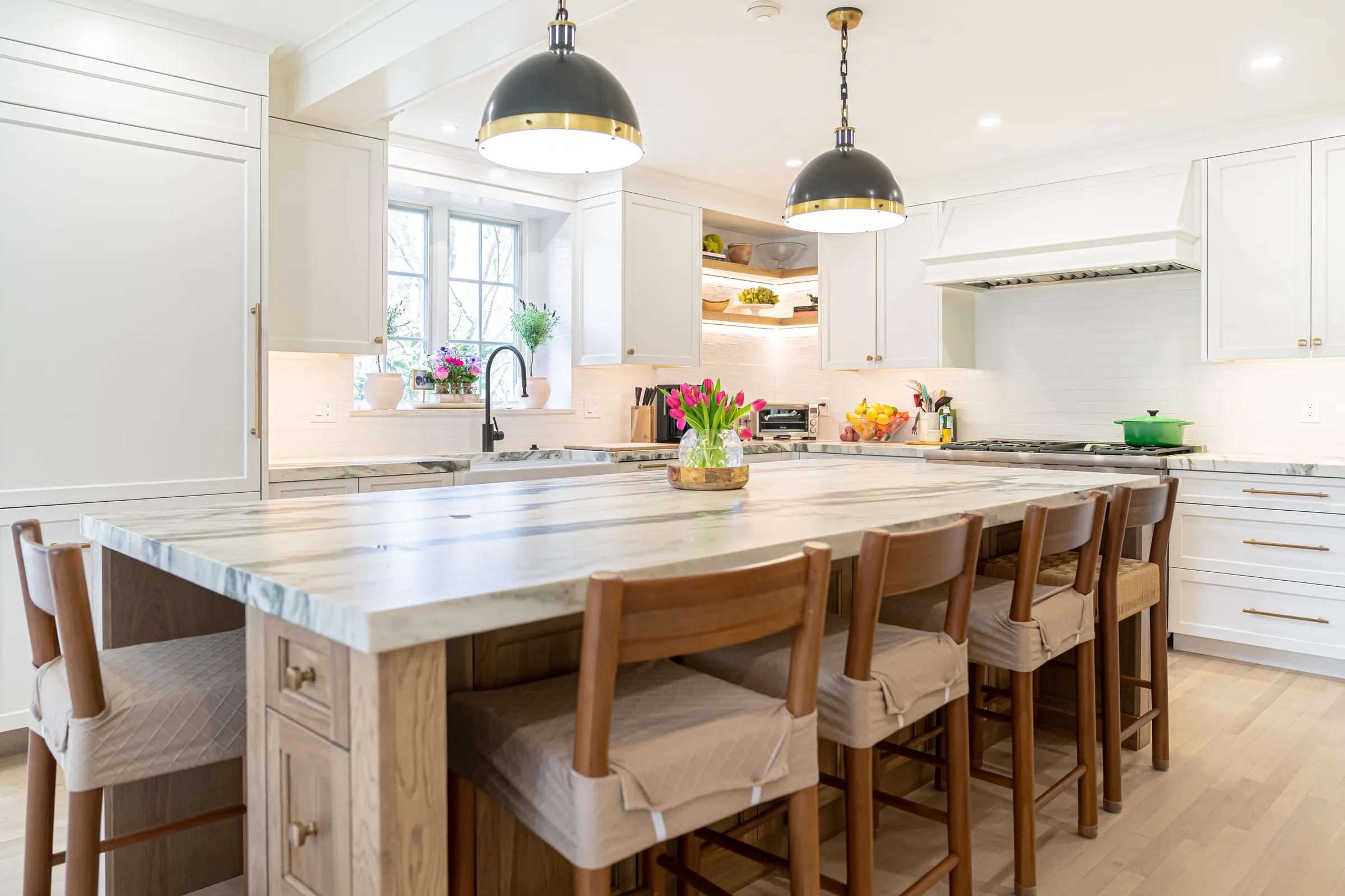 Quartzite island with seating in a white kitchen in Wellesley, MA